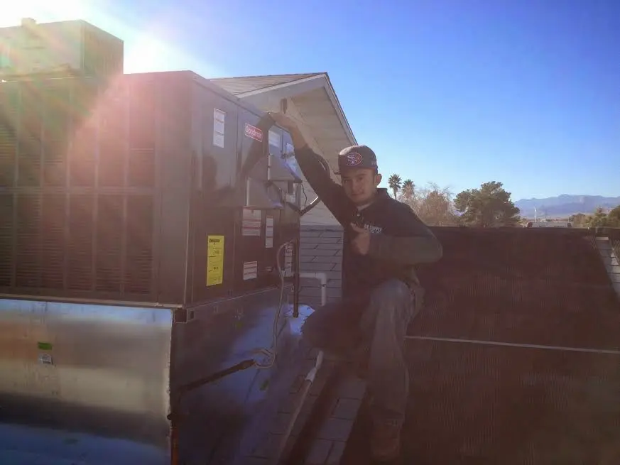 HVAC technician performing HVAC Inspection on a rooftop unit in Dalhart